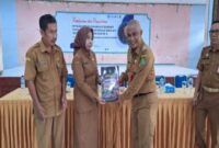 Kepala Dinas Pendidikan Kabupaten Sumenep, Mohamad Iksan, S.Pd.,M.T, saat menyerahkan surat keputusan Bupati Sumenep kepada salah satu kepala sekolah.