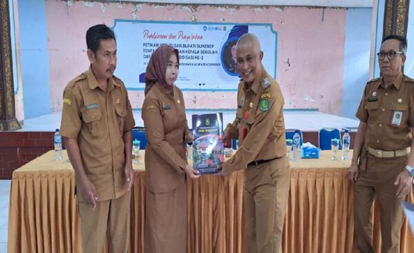 Kepala Dinas Pendidikan Kabupaten Sumenep, Mohamad Iksan, S.Pd.,M.T, saat menyerahkan surat keputusan Bupati Sumenep kepada salah satu kepala sekolah.