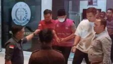 Tersangka MF (baju rompi bermasker) keluar dari gedung Kejari Sampang dan digelandang ke mobil tahanan, pada Kamis (27/8/2026) malam