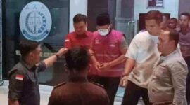 Tersangka MF (baju rompi bermasker) keluar dari gedung Kejari Sampang dan digelandang ke mobil tahanan, pada Kamis (27/8/2026) malam
