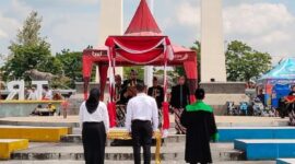 Dua orang perwakilan PPPK Paruh Waktu saat di sumpah pada penyerahan SK di Alun-alun Trunojoyo, Sampang, setahun yang lalu. Foto: Istimewa.