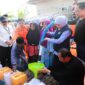 Gubernur Jawa Timur, Khofifah Indar Parawansa, saat mendistribusikan air bersih saat lakukan kunjungan kerja di Kabupaten Sumenep. Rabu (14/10/2026). 